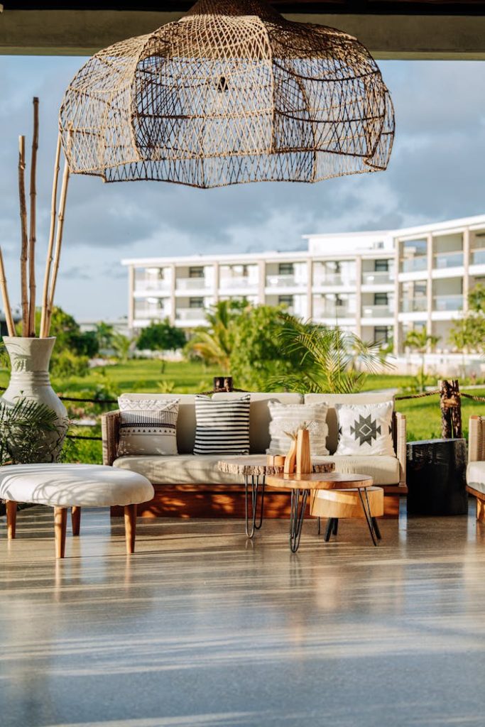 sofa-and-table-on-terrace-19199133 Elegant outdoor terrace in Zanzibar showcasing modern furniture and lush greenery, perfect for relaxation.